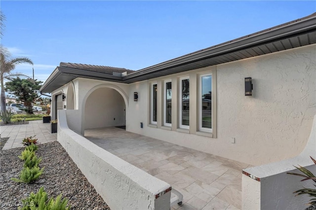 view of side of home featuring a patio and a garage