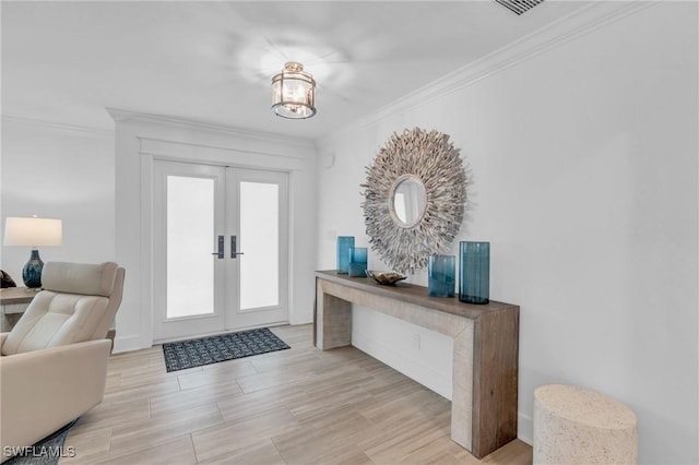 entrance foyer featuring light hardwood / wood-style flooring, crown molding, and french doors