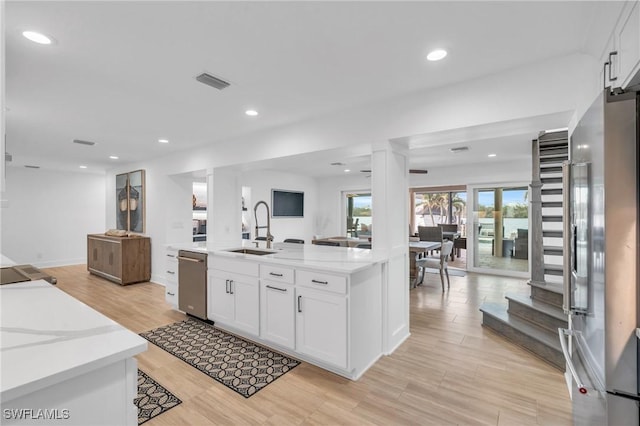 kitchen featuring white cabinets, light wood-type flooring, sink, and appliances with stainless steel finishes