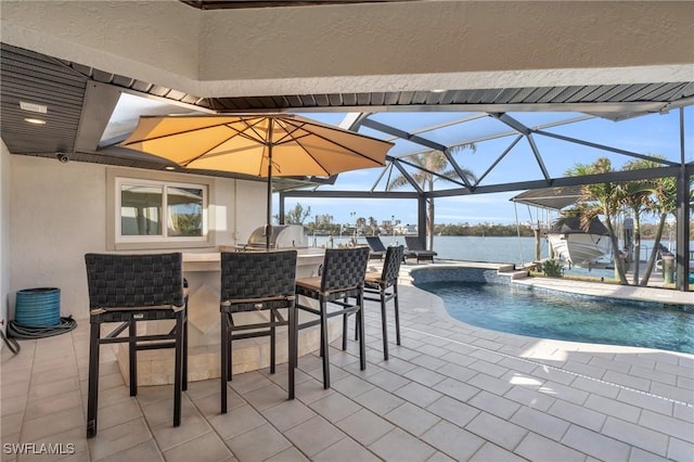 view of pool featuring a water view, an outdoor bar, glass enclosure, and a patio area