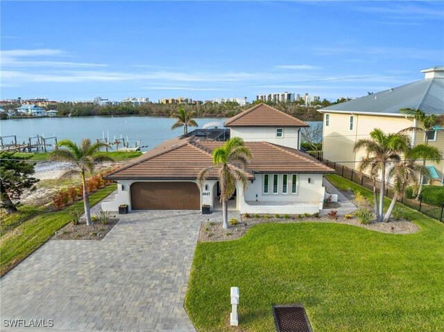 view of front of property with a front lawn, a water view, and a garage