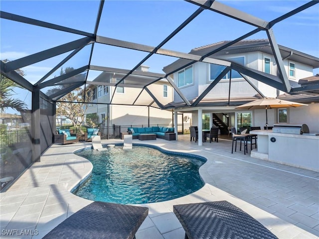 view of swimming pool with outdoor lounge area, glass enclosure, an outdoor bar, a patio area, and area for grilling