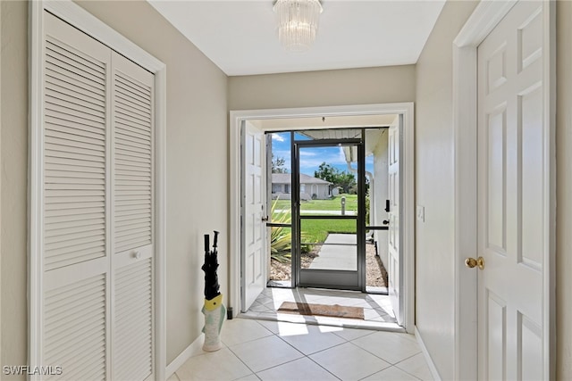 entryway with a chandelier and light tile patterned floors