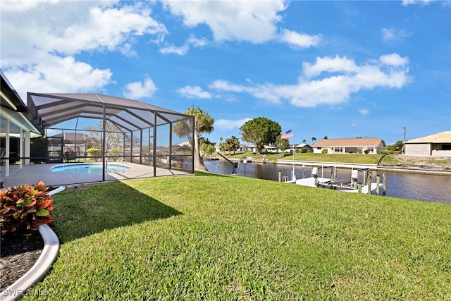 view of yard with glass enclosure, a water view, and a dock