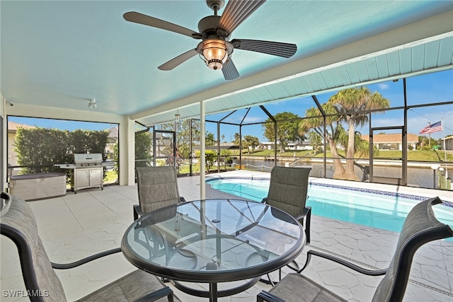 view of pool featuring area for grilling, glass enclosure, ceiling fan, and a patio area