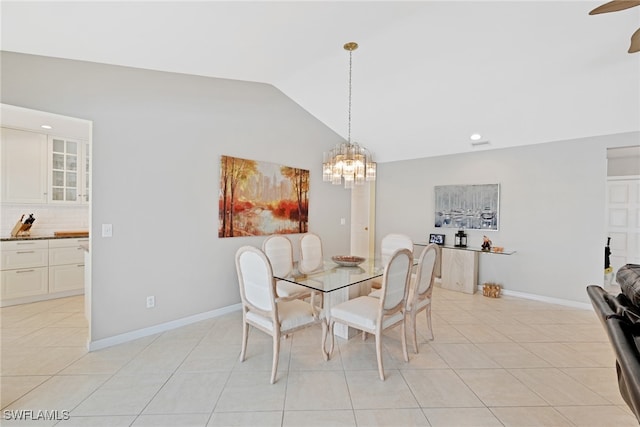 dining space with ceiling fan with notable chandelier, light tile patterned flooring, and lofted ceiling