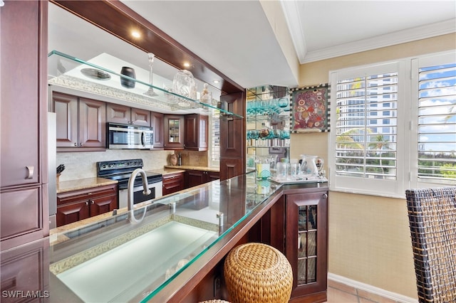 bar featuring crown molding, light tile patterned floors, a healthy amount of sunlight, and appliances with stainless steel finishes