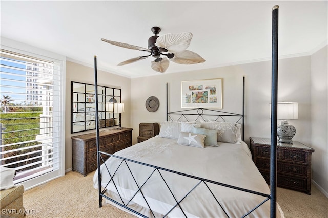 bedroom featuring multiple windows, ceiling fan, crown molding, and light carpet