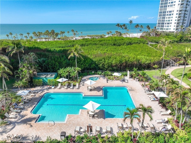 view of swimming pool with a water view and a patio area