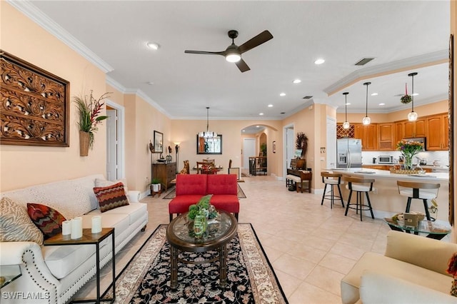 living area with visible vents, ceiling fan, ornamental molding, recessed lighting, and arched walkways