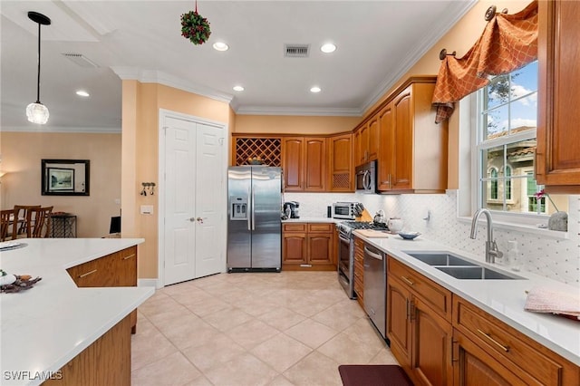 kitchen featuring a sink, appliances with stainless steel finishes, brown cabinetry, and light countertops