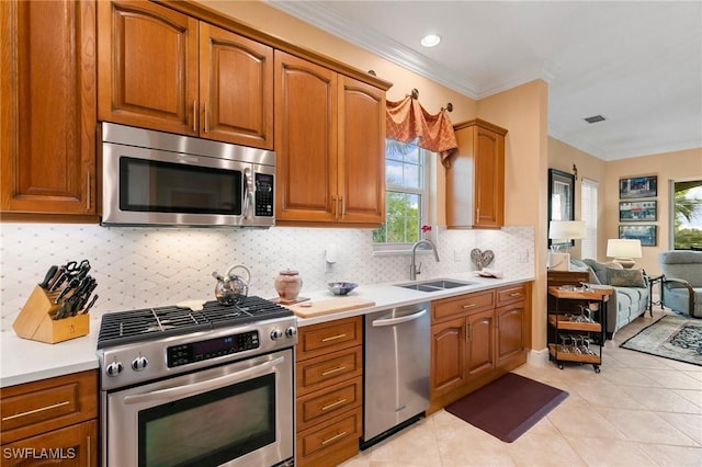 kitchen featuring a sink, open floor plan, stainless steel appliances, crown molding, and light countertops