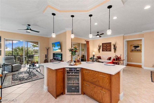 kitchen with wine cooler, open floor plan, light countertops, and ornamental molding