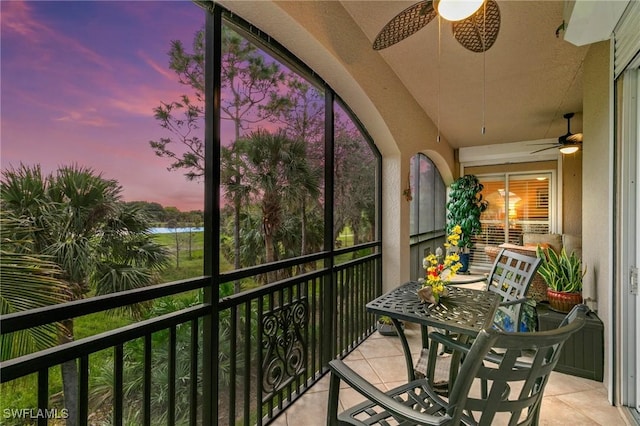 balcony featuring a water view and a ceiling fan