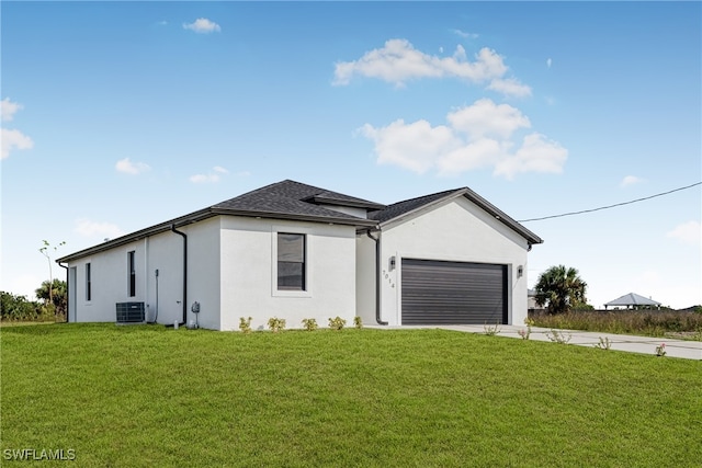 view of front of home with central AC, a front lawn, and a garage