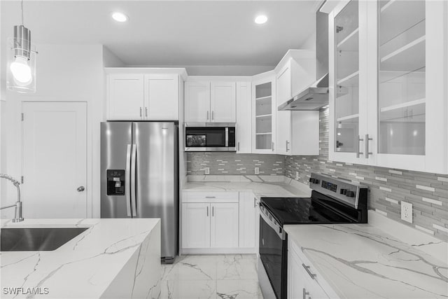 7014 Alfa Cir, Labelle, FL 33935 - kitchen with stainless steel appliances, wall chimney exhaust hood, a sink, light marble finish floors, and white cabinets