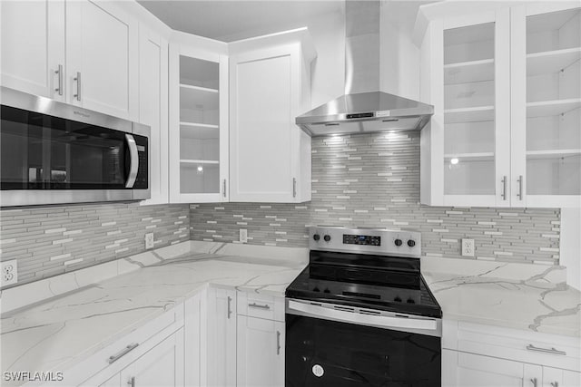7014 Alfa Cir, Labelle, FL 33935 - kitchen featuring stainless steel appliances, wall chimney exhaust hood, backsplash, and white cabinetry