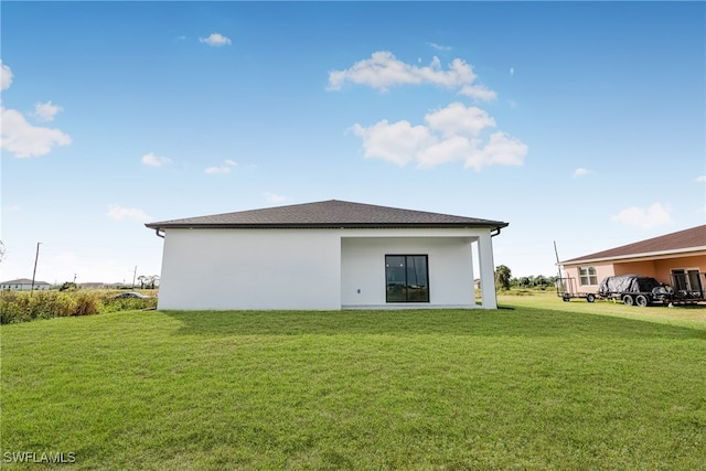 rear view of property with a lawn