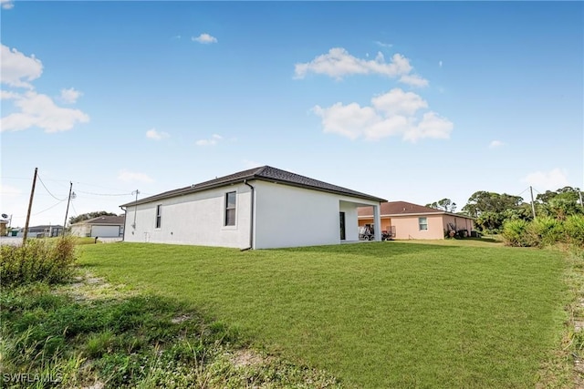 7014 Alfa Cir, Labelle, FL 33935 - rear view of property featuring a lawn and stucco siding