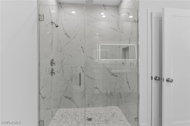 bathroom featuring a shower with door