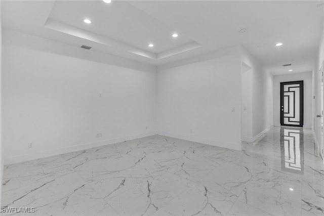 unfurnished room with a tray ceiling