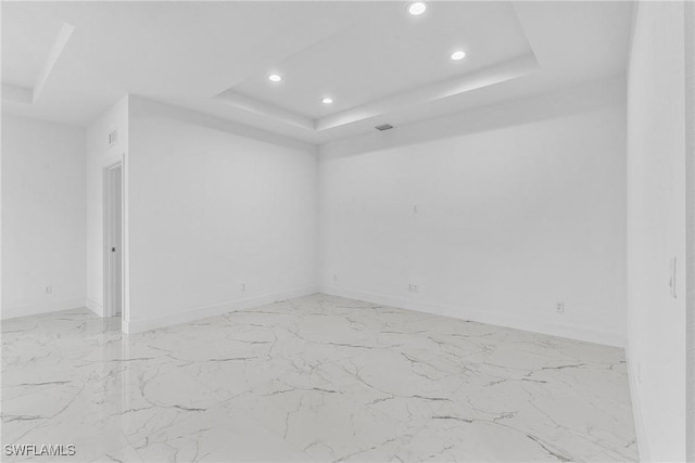 7014 Alfa Cir, Labelle, FL 33935 - unfurnished room featuring a tray ceiling, recessed lighting, light marble finish flooring, and baseboards
