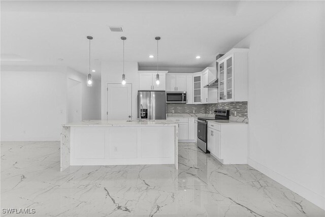 7014 Alfa Cir, Labelle, FL 33935 - kitchen featuring stainless steel appliances, tasteful backsplash, white cabinets, pendant lighting, and wall chimney range hood