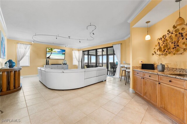 living room featuring plenty of natural light, light tile patterned flooring, and ornamental molding