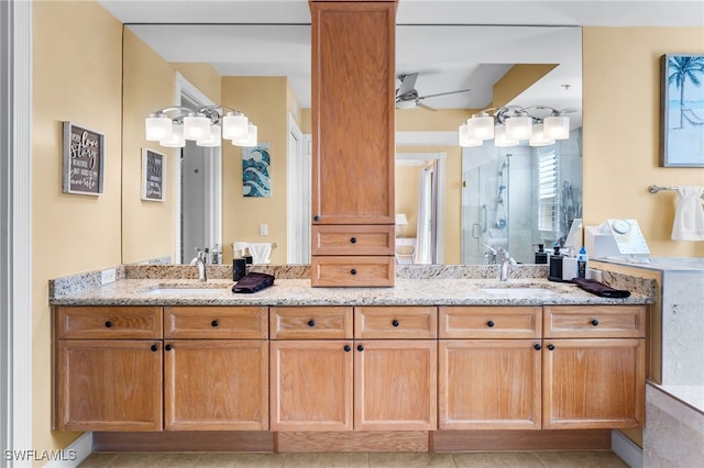 bathroom with ceiling fan, a shower stall, a sink, and double vanity