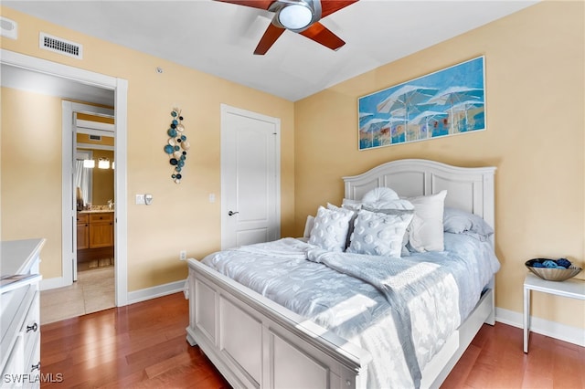 bedroom featuring visible vents, ceiling fan, baseboards, and wood finished floors