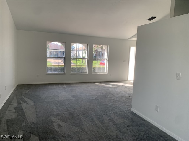 carpeted empty room with lofted ceiling