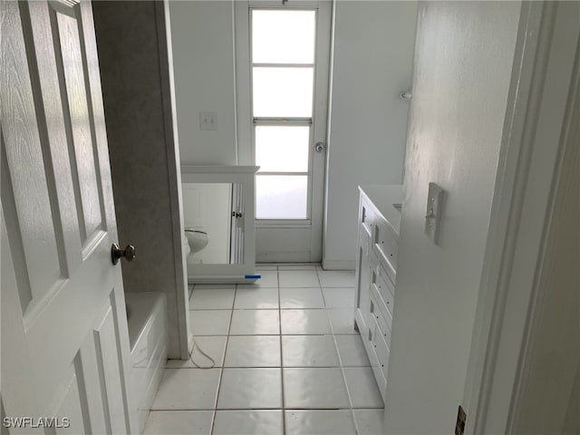 bathroom with tile patterned flooring and a washtub