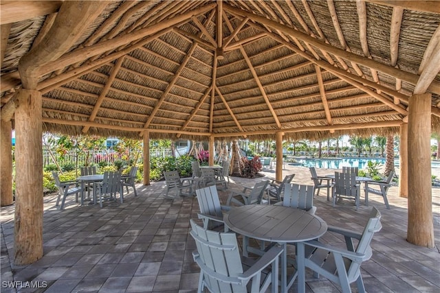 view of patio with a gazebo, fence, and outdoor dining space