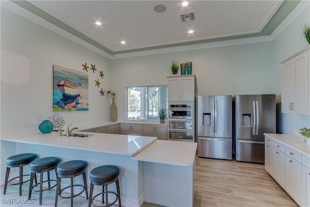 kitchen featuring light wood-style floors, a breakfast bar area, stainless steel refrigerator with ice dispenser, and light countertops