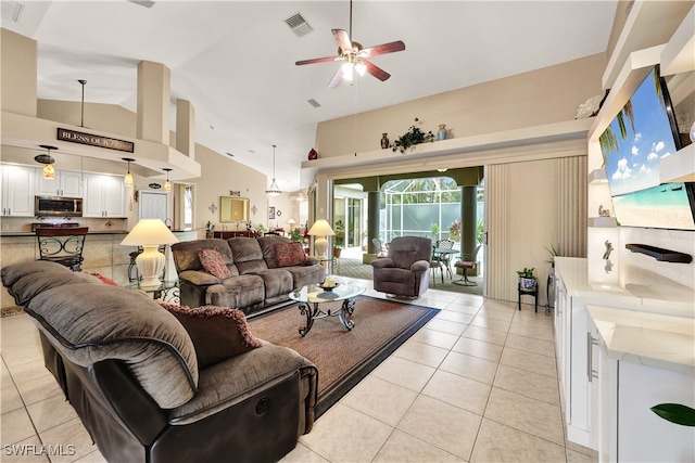 tiled living room with ceiling fan and high vaulted ceiling