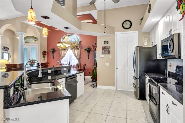 kitchen featuring white cabinets, pendant lighting, dark stone countertops, and appliances with stainless steel finishes