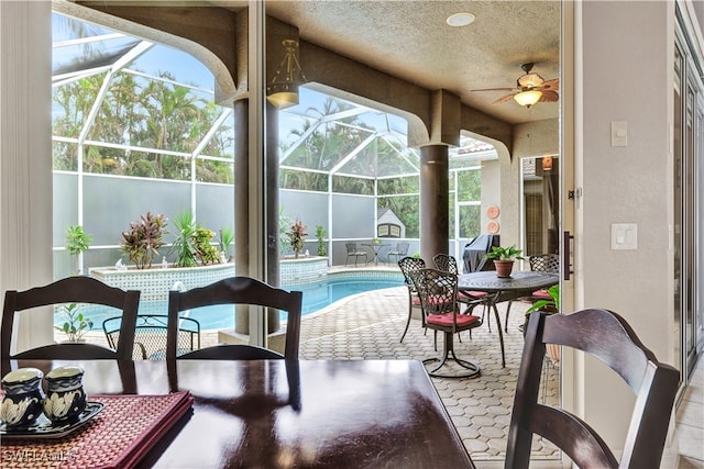 sunroom / solarium with ceiling fan, a healthy amount of sunlight, and a pool