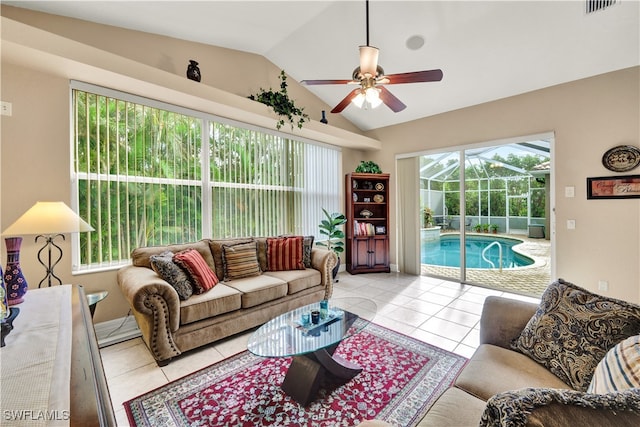 living room featuring ceiling fan, light tile patterned flooring, a healthy amount of sunlight, and vaulted ceiling