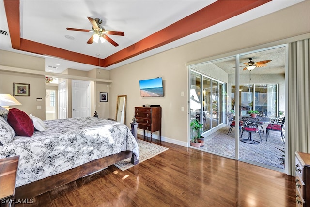 bedroom with hardwood / wood-style floors, ceiling fan, access to outside, and a tray ceiling