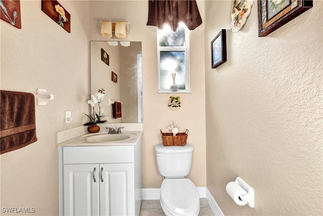 bathroom with tile patterned flooring, vanity, and toilet