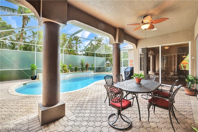 view of pool with a lanai, a patio area, and ceiling fan