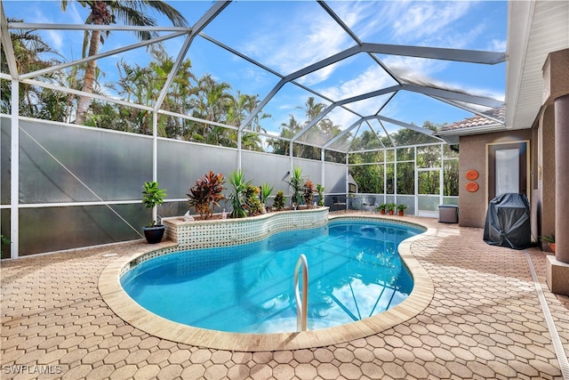 view of pool with glass enclosure and a patio area