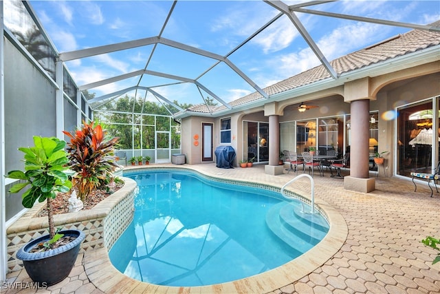 view of swimming pool with glass enclosure and a patio area