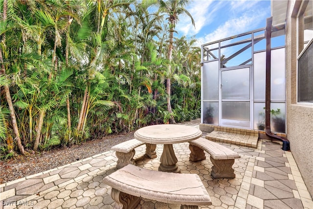 view of patio featuring a lanai