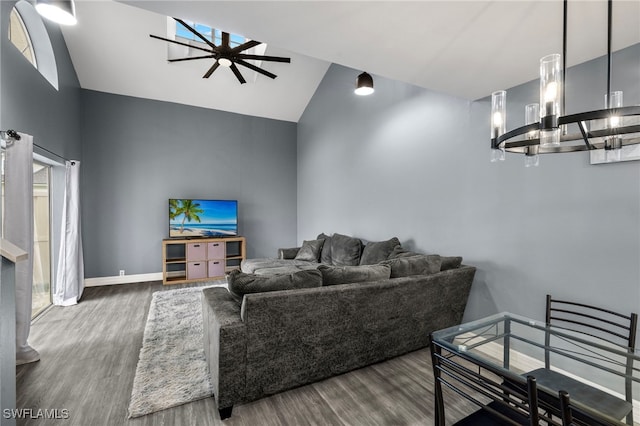 living room with hardwood / wood-style flooring, ceiling fan with notable chandelier, and high vaulted ceiling