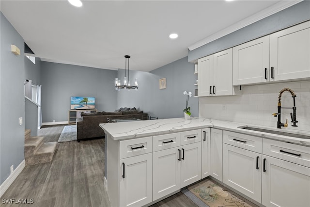 kitchen featuring kitchen peninsula, white cabinetry, and sink