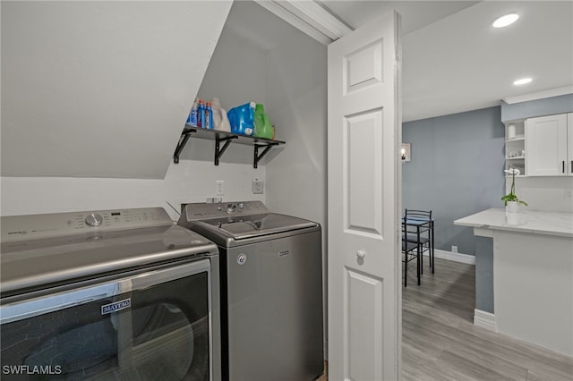 laundry room with light hardwood / wood-style floors and washing machine and dryer