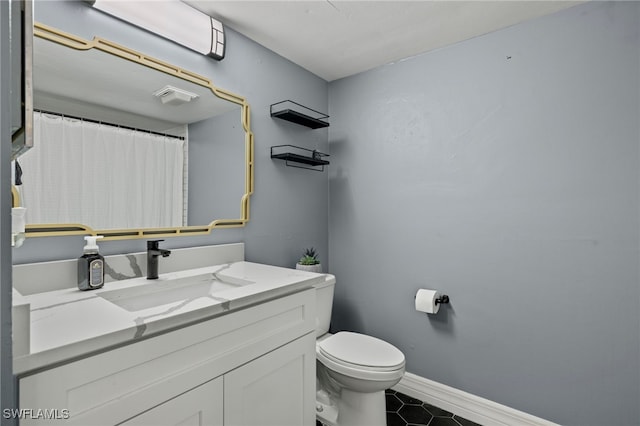 bathroom with tile patterned flooring, vanity, and toilet