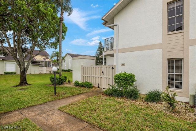 view of side of property with a yard and a balcony