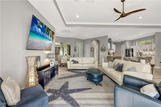 living room featuring arched walkways, a ceiling fan, wood finished floors, crown molding, and recessed lighting